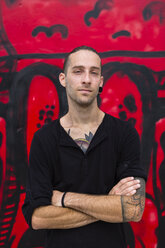 Portrait of man in front of a graffiti wall - MGIF00002