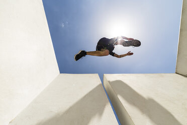 Ein Mann springt während einer Parkour-Session durch die Stadt - MGIF00010