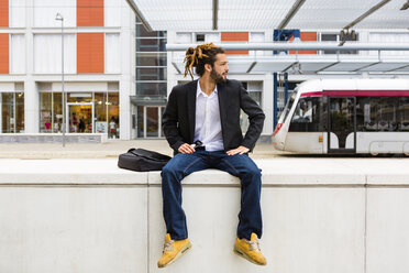 Junger Geschäftsmann mit Dreadlocks wartet am Bahnhof - MGIF00020