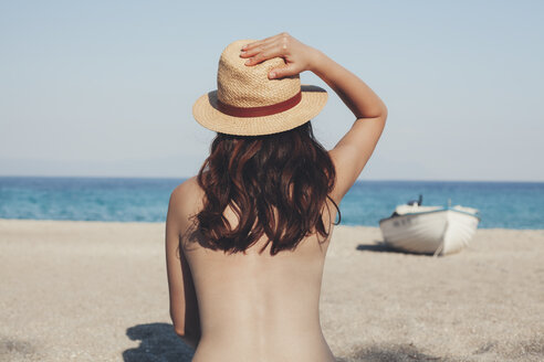 Greece, young woman on the beach looking at the sea - BZF00370