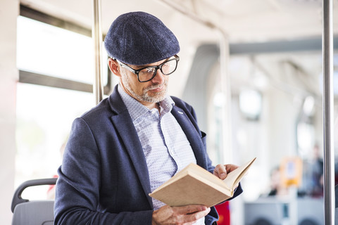Man in bus reading book stock photo