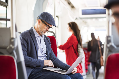 Businessman using laptop in bus stock photo