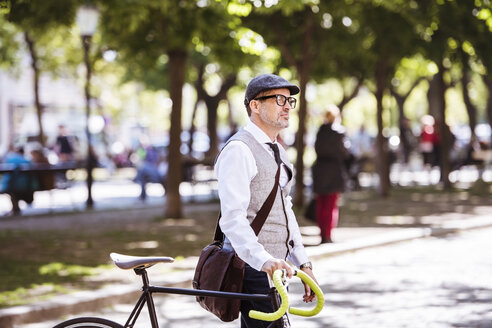 Mature businessman on bicycle in the city - HAPF01780