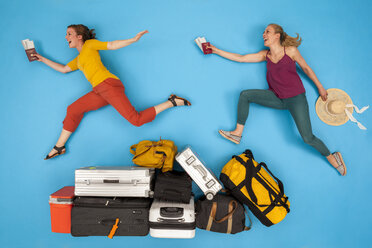Freunde, die über Gepäck springen und glücklich aussehen - BAEF01375