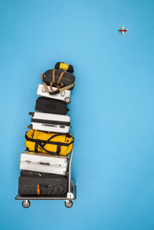 Stacked luggage and plane flying in the sky - BAEF01393