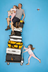Mädchen, das einen Gepäckwagen schiebt, auf dem die Eltern sitzen - BAEF01395