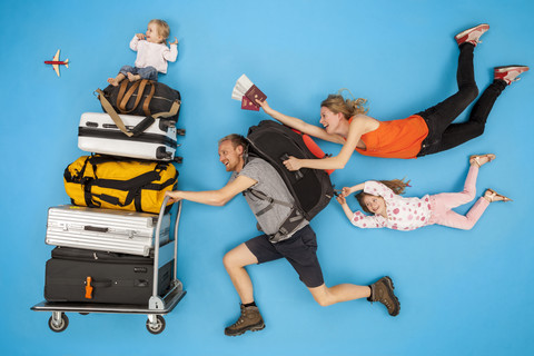 Familie mit Gepäckwagen eilt zur Abfahrt, lizenzfreies Stockfoto