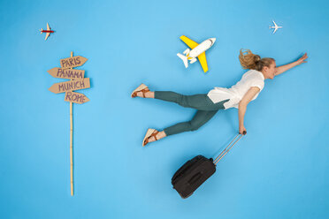 Frau mit Koffer, die sich beeilt, ihren Flug für eine Städtereise zu bekommen - BAEF01439