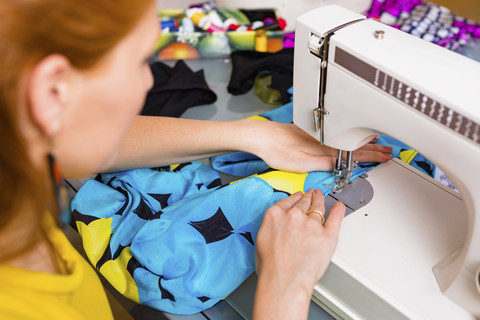 Modedesignerin bei der Arbeit mit der Nähmaschine, lizenzfreies Stockfoto