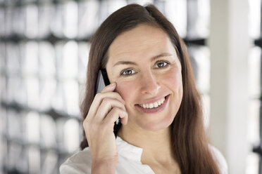 Porträt einer lächelnden Geschäftsfrau am Telefon - DMOF00025
