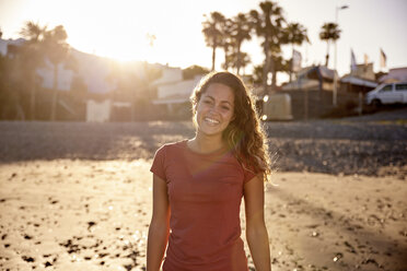 Porträt einer glücklichen Frau am Strand in der Abenddämmerung - PACF00025