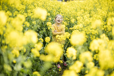 Laughing girl standing in rape field - MOEF00013