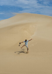 Australia, Port Lincoln, man running down sand dune - TOVF00082