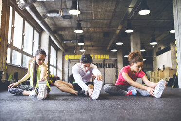 Three young people stretching in gym - HAPF01790