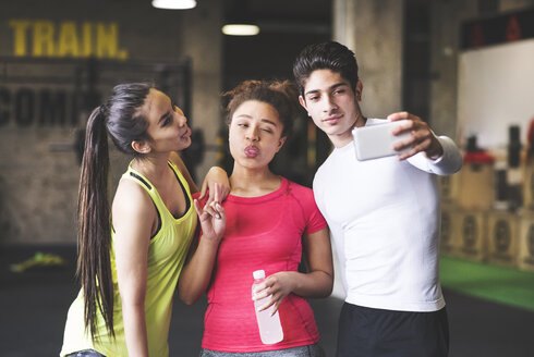 Drei verspielte junge Leute machen ein Selfie in der Turnhalle - HAPF01795