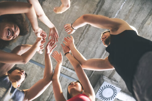 Group of young people huddling in gym - HAPF01841