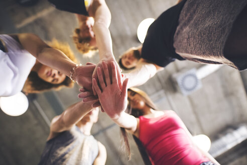 Group of young people huddling in gym - HAPF01842