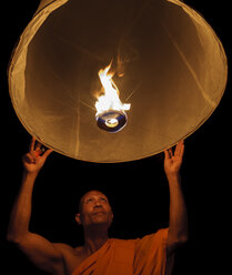 Thailand, Chiang Mai, Buddhist monk lighting lantern - TOVF00084