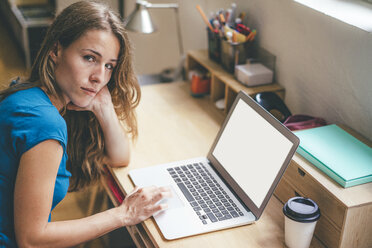 Junge Frau mit Kaffee zum Mitnehmen und Laptop zu Hause - KNSF01634