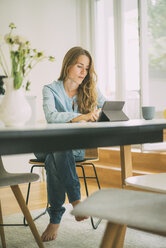 Young woman using tablet at home - KNSF01662