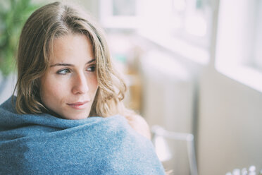 Portrait of young woman wrapped in a blanket - KNSF01667