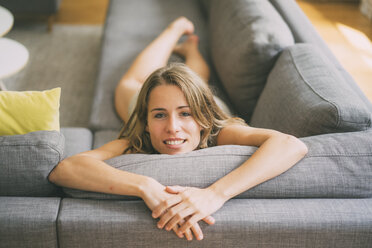 Portrait of young woman relaxing on couch at home - KNSF01686