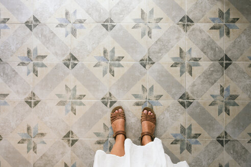 Woman standing on ornate tiled floor - GEMF01699
