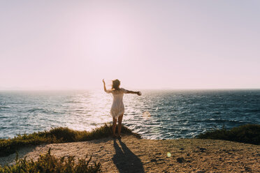 Greece, Cyclades, Naxos, woman standing at the sea at sunset - GEMF01705