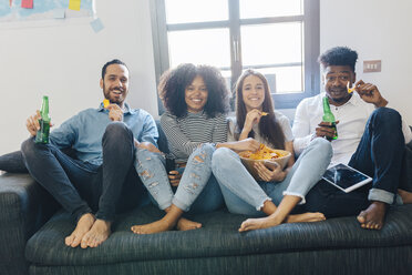 Portrait of happy friends sitting on the sofa - GIOF02787