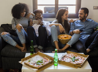 Happy friends socializing on the sofa - GIOF02793