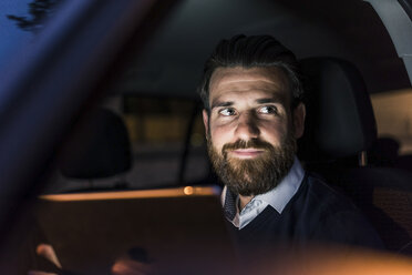 Porträt eines selbstbewussten Geschäftsmannes im Auto bei Nacht - UUF10880