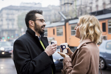 Geschäftsmann und Geschäftsfrau mit Kaffee zum Mitnehmen in der Stadt - MAUF01099