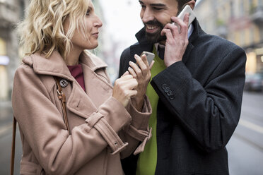 Happy business couple with cell phones in the city - MAUF01102