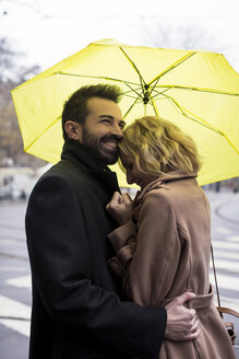 Glückliches Geschäftspaar unter einem Regenschirm in der Stadt - MAUF01107