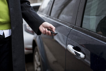 Close-up of businessman opening car with remote control - MAUF01114