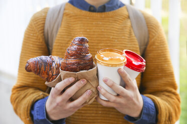 Young man with croissant and coffee to go - RTBF00938