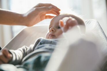 Die Hand der Frau berührt die Stirn des Babys - MFF03680