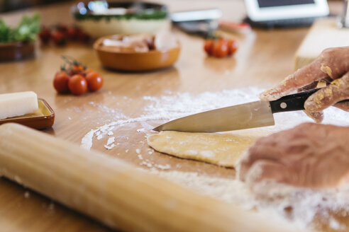 Hände schneiden Teig für frische Ravioli - JRFF01400