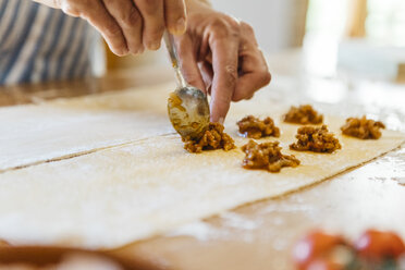 Woman's hands putting ravioli stuffing on dough - JRFF01402