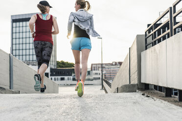 Two women running in the city - UUF10938