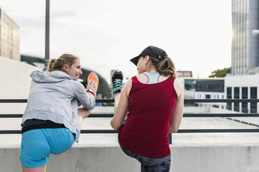 Zwei aktive Frauen beim Stretching in der Stadt - UUF10941