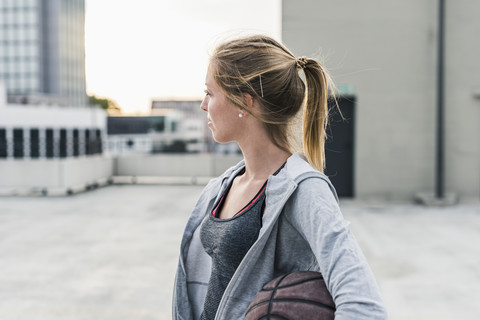 Woman holding basketball on parking level in the city stock photo