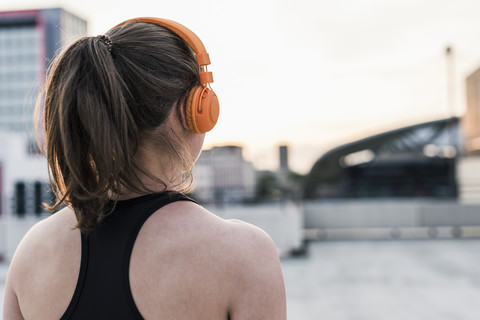 Active woman wearing headphones on parking level in the city stock photo