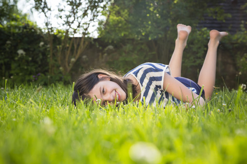 Portrait of smiling girl lying on a meadow in summer stock photo