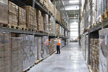 Man in factory hall wearing safety looking up - LYF00738