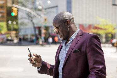 Stylish businessman looking at smartphone - MAUF01135