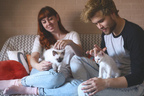 Young couple with kittens on the couch at home - RTBF00969