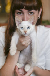 Portrait of white kitten with owner in the background - RTBF00980