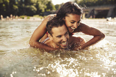 Laughing couple bathing together in river - SUF00153