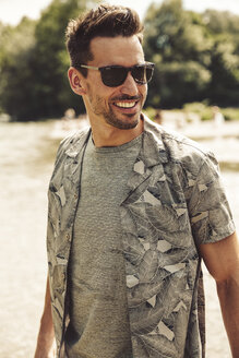 Porträt eines lächelnden Mannes mit Sonnenbrille - SUF00157
